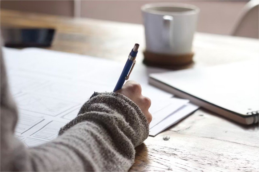 Persona organizando ideas y escribiendo una guía